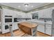 Charming kitchen featuring a convenient island, white cabinetry, and a stainless steel wall oven at 1920 Hillock Dr, Raleigh, NC 27612
