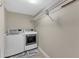 Bright laundry room with washer, dryer, and wire shelving above for convenient storage at 1920 Hillock Dr, Raleigh, NC 27612