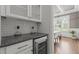 A stylish bar area features a wine refrigerator, white cabinets, and a view into the dining room at 2077 Amalfi Pl, Apex, NC 27502