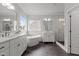 Spacious bathroom with a soaking tub, tiled shower, dual sinks, and a large window at 2077 Amalfi Pl, Apex, NC 27502