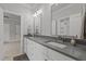 Bathroom featuring dual sinks, white cabinetry, and a doorway to the bedroom at 2077 Amalfi Pl, Apex, NC 27502