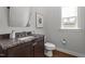 Powder room with granite countertop, a decorative mirror, and modern fixtures at 2077 Amalfi Pl, Apex, NC 27502