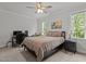Bedroom featuring a bed, desk with computer, ceiling fan, and large windows for ample natural light at 2077 Amalfi Pl, Apex, NC 27502