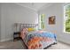 Bright bedroom featuring a comfortable bed with colorful bedding, a side table, and a window with natural light at 2077 Amalfi Pl, Apex, NC 27502