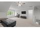 Spacious bonus room with natural light, carpeted floors, and comfortable seating and storage space at 2077 Amalfi Pl, Apex, NC 27502