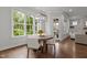 Dining area with a wooden table, modern chandelier, large windows, and hardwood flooring at 2077 Amalfi Pl, Apex, NC 27502