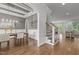 Dining area boasting a stylish chandelier, white wainscoting, and hardwood floors at 2077 Amalfi Pl, Apex, NC 27502