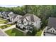 Two-story home featuring manicured lawns, gray roof, attached garages, and mature trees at 2077 Amalfi Pl, Apex, NC 27502