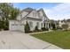 Elegant two-story home featuring a two-car garage, manicured lawn, and beautiful landscaping at 2077 Amalfi Pl, Apex, NC 27502