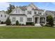 Charming two-story home with white brick, wood trim and gray shutters surrounded by a lush, green lawn at 2077 Amalfi Pl, Apex, NC 27502