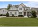 Charming two-story home with white brick, wood trim and gray shutters surrounded by a lush, green lawn at 2077 Amalfi Pl, Apex, NC 27502