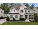 Charming two-story home with white brick, wood trim and gray shutters surrounded by a lush, green lawn at 2077 Amalfi Pl, Apex, NC 27502