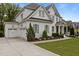 Elegant two-story home featuring a two-car garage, manicured lawn, and beautiful landscaping at 2077 Amalfi Pl, Apex, NC 27502
