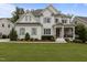 Charming two-story home with white brick, wood trim and gray shutters surrounded by a lush, green lawn at 2077 Amalfi Pl, Apex, NC 27502