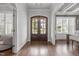 Grand foyer featuring hardwood floors and a beautiful wood-frame front door at 2077 Amalfi Pl, Apex, NC 27502