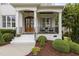 A home's inviting front porch features a double-door entryway, stylish seating, and elegant column supports at 2077 Amalfi Pl, Apex, NC 27502