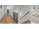Hallway with hardwood floors and a staircase leading to an upstairs living area and laundry room at 2077 Amalfi Pl, Apex, NC 27502