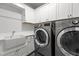 Laundry room equipped with front-load washer/dryer and a farmhouse sink at 2077 Amalfi Pl, Apex, NC 27502