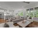 Open-concept living room features an eat-in kitchen, large windows, and hardwood flooring at 2077 Amalfi Pl, Apex, NC 27502