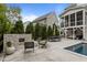 Spacious outdoor patio with a stone fireplace, dining area, and lush landscaping at 2077 Amalfi Pl, Apex, NC 27502