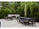 Spacious outdoor patio with a stone fireplace, dining area, and lush landscaping at 2077 Amalfi Pl, Apex, NC 27502