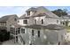 Back of a two-story home with white siding, large windows, screened porch, and staircase at 2077 Amalfi Pl, Apex, NC 27502