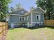 Exterior rear view of home with deck stairs, green yard, and a freshly stained wooden fence at 2106 University Dr, Durham, NC 27707