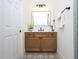 Bathroom with patterned tile floors, wood vanity, black hardware, and a framed mirror at 2106 University Dr, Durham, NC 27707