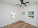 Bright bedroom features two windows, light hardwood floors, and a modern ceiling fan at 2106 University Dr, Durham, NC 27707