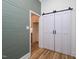 Hallway features modern sliding barn doors, green shiplap accent wall, and access to additional spaces at 2106 University Dr, Durham, NC 27707