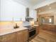 A kitchen area with a stainless steel stove, wood cabinets, granite countertops, and recessed lighting at 2106 University Dr, Durham, NC 27707