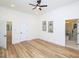 Spacious main bedroom with wood floors, two windows, and a door leading to a bathroom at 2106 University Dr, Durham, NC 27707