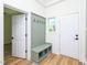 Inviting mudroom with custom built-in bench and storage; side door access and light wood flooring at 2106 University Dr, Durham, NC 27707