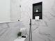 A tiled shower stall featuring black matte fixtures, a glass enclosure, and marble patterned walls at 2106 University Dr, Durham, NC 27707