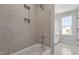 Elegant bathroom featuring tiled walls, recessed shower niche, and natural light at 2178 Pink Peony Circle Lot 167 Cir, Durham, NC 27703