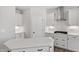 Modern kitchen featuring white cabinets, stainless steel hood, and a spacious island with quartz countertop at 2178 Pink Peony Circle Lot 167 Cir, Durham, NC 27703