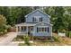Charming home showcases a classic facade, complemented by manicured landscaping and a quaint covered porch at 225 Sacred Fire Rd, Louisburg, NC 27549