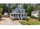 Charming two-story home boasts a welcoming front porch, complemented by verdant landscaping and natural surroundings at 225 Sacred Fire Rd, Louisburg, NC 27549