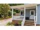 Charming front porch with brick steps and a white railing at 225 Sacred Fire Rd, Louisburg, NC 27549