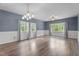 Bright, open living room featuring hardwood floors, wainscoting, elegant lighting, and lots of natural light at 225 Sacred Fire Rd, Louisburg, NC 27549