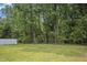 A large, grassy backyard with a white fence along the property line at 235 Eason Creek Way, Clayton, NC 27527