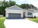 View of a single-story home with a gray two-car garage, light-blue shutters, and a well-manicured lawn at 235 Eason Creek Way, Clayton, NC 27527