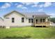 Back exterior of the home with a porch and a grassy lawn at 235 Eason Creek Way, Clayton, NC 27527