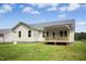 Back exterior of the home with a porch and a grassy lawn at 235 Eason Creek Way, Clayton, NC 27527