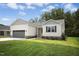 Attractive single-story house showcasing light grey siding, a well kept lawn, and a grey garage at 235 Eason Creek Way, Clayton, NC 27527