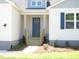 View of the home's light-blue front door with wooden steps leading to the entryway at 235 Eason Creek Way, Clayton, NC 27527