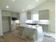 Well-lit kitchen with white cabinets, granite countertops, and a central island, awaiting final finishes at 235 Eason Creek Way, Clayton, NC 27527