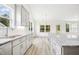Bright kitchen featuring a sink, granite countertops, white cabinets, and wood-look flooring at 235 Eason Creek Way, Clayton, NC 27527