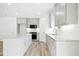 Well-lit kitchen with an island, white cabinets, and wood-look flooring at 235 Eason Creek Way, Clayton, NC 27527