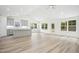 Open-concept living space featuring wood-look floors and natural light through bright windows at 235 Eason Creek Way, Clayton, NC 27527
